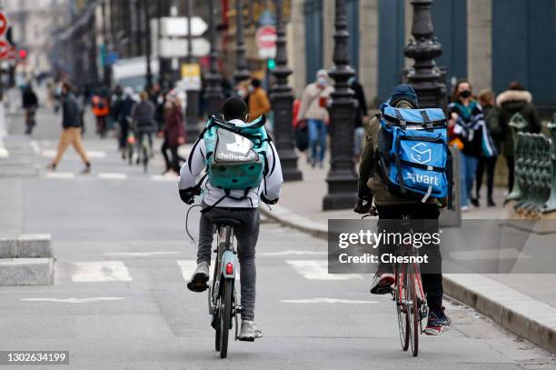 Food deliverers for Stuart and Deliveroo ride their bicycles during the coronavirus outbreak on February 17 in Paris, France. With the closure of...