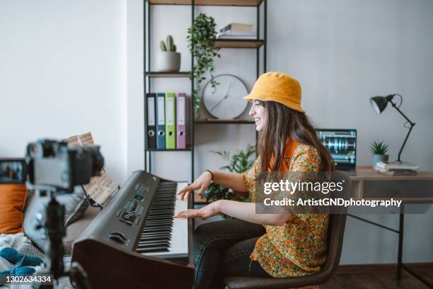 young female musician playing piano and recording with camera. - electric piano stock pictures, royalty-free photos & images