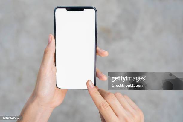 close up of woman hand holding smartphone on white background, cropped hand using smartphone on the background of polished cement - hands holding photos et images de collection