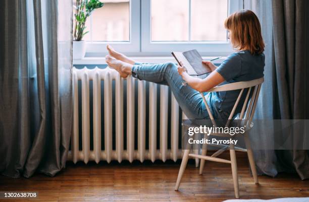 a young woman taking a break from technology - radiator heater stock pictures, royalty-free photos & images