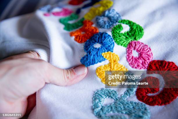 sudadera blanca con frontal bordado con letras de colores - bordado stockfoto's en -beelden