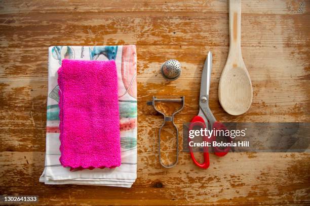 bodegón de utensilios de cocina: trapo, tijeras, pelador y cuchara de madera - trapo de cocina stock pictures, royalty-free photos & images