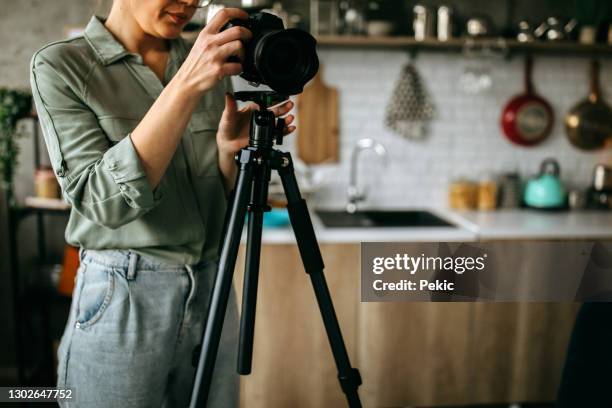 junge fotografin richtet ihre kamera ein - spiegelreflexkamera stock-fotos und bilder