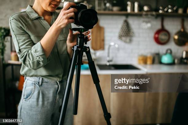 young female photographer seting up her camera - professional photo shoot stock pictures, royalty-free photos & images