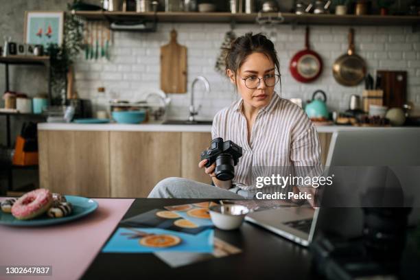 joven fotógrafa que trabaja en su estudio de oficina en casa - deitar fotografías e imágenes de stock