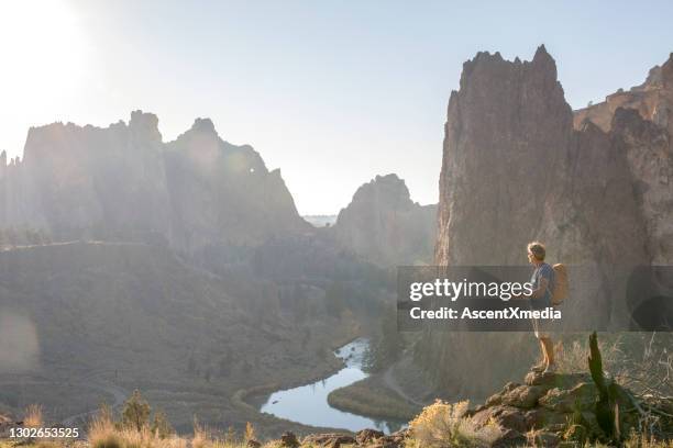 de wandelingen van de mens langs zonnige bergrug in de ochtend - smith rock state park stockfoto's en -beelden