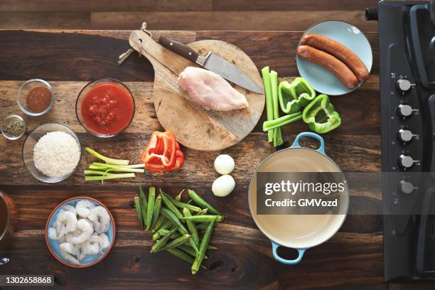 preparing cajun style chicken, shrimp and sausage jambalaya in a cast iron pot - southern food stock pictures, royalty-free photos & images