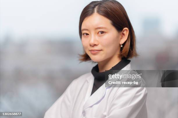 verticale du jeune docteur féminin - blouse blanche femme photos et images de collection