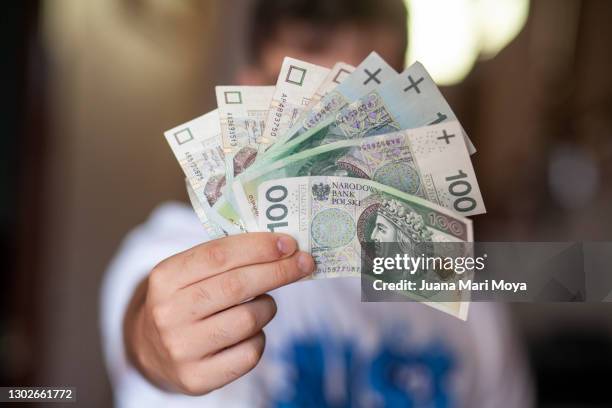 university boy shows some zloty bills, for when he goes on a student exchange, to poland - arbeitgeberzuschuss stock-fotos und bilder