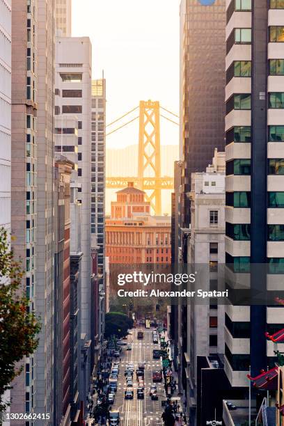 oakland bay bridge seen between skyscrapers of san francisco financial district, california, usa - san francisco bay bridge 個照片及圖片檔