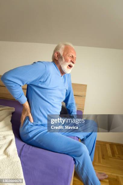 senior man in pain waking up - hip stock pictures, royalty-free photos & images