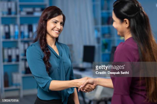 business women shaking hands on business event after deal on interview stock photo - corporate business stock pictures, royalty-free photos & images