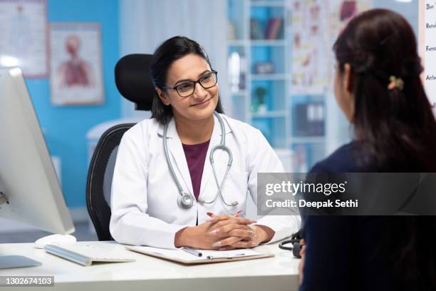 arzt und patient diskutieren in der klinik und schreiben verschreibungsmedizin stockfoto - indian doctors stock-fotos und bilder