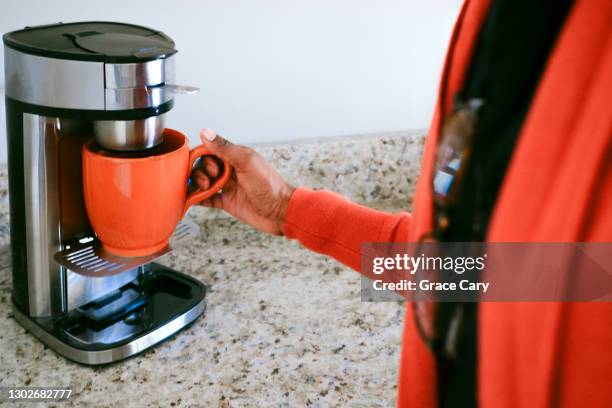 woman brews cup of coffee - coffee machine home stock pictures, royalty-free photos & images