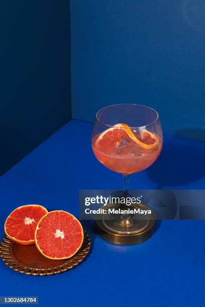 pop art style gin cocktail con pompelmo agrumi in sfondo blu - food styling foto e immagini stock