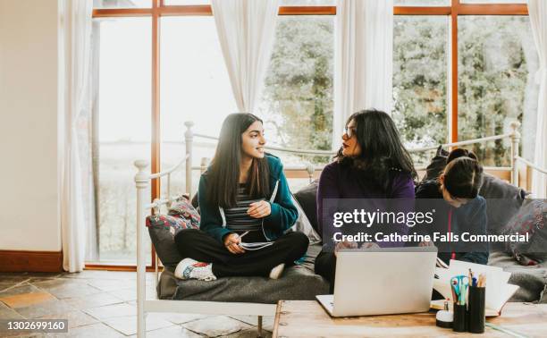 a mother listens to her teenage daughter intently during a homeschooling session - leanincollection working women fotografías e imágenes de stock