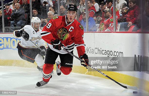 Jonathan Toews of the Chicago Blackhawks takes control of the puck as Francois Beauchemin of the Anaheim Ducks turns sharp around the boards, during...
