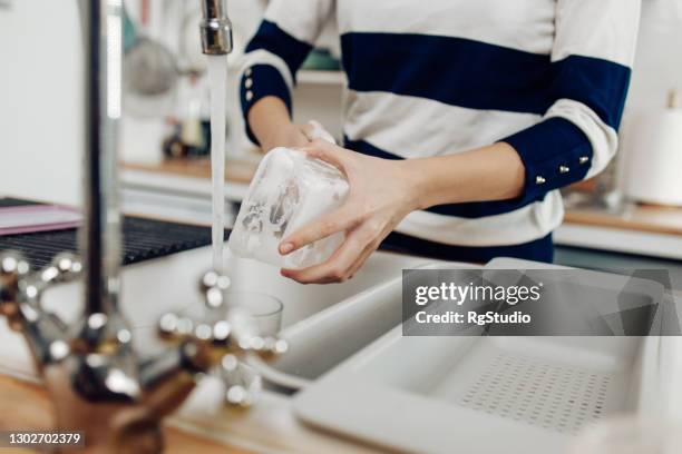 unrecognizable girl washing plastic dishes - lavar imagens e fotografias de stock