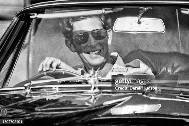 Charles, Prince of Wales pictured wearing sunglasses, smiling at the wheel of his Aston Martin sports car at the Windsor, England polo grounds.(Photo...