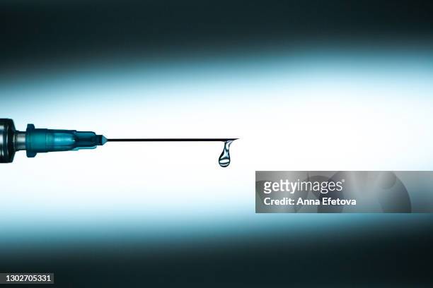 drop of vaccine on needle of syringe - needle fotografías e imágenes de stock
