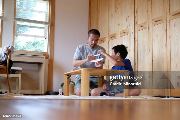 father and son making paper plane - origami asia stock pictures, royalty-free photos & images