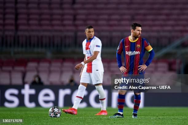 Lionel Messi of FC Barcelona looks dejected as Kylian Mbappe of Paris Saint-Germain walks past him after the third goal of Paris Saint-Germain scored...