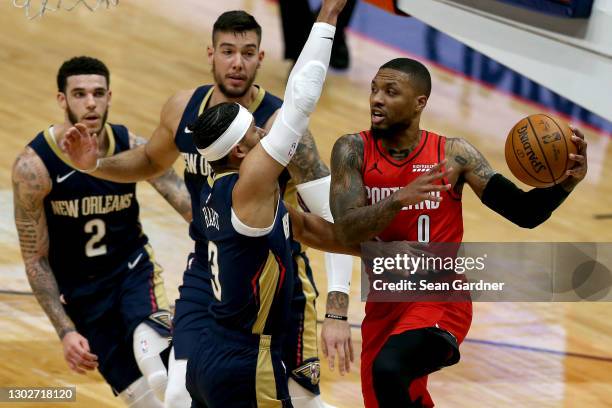 Damian Lillard of the Portland Trail Blazers looks to pass over Josh Hart of the New Orleans Pelicans during the first quarter of an NBA game at...