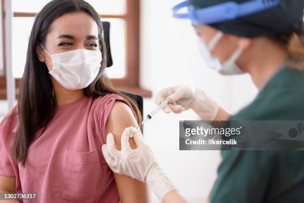ärztin oder krankenschwester, die covid-19-impfung an ihren patienten in der klinik abgeschossen hat - vaccination center stock-fotos und bilder