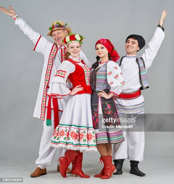 deux paires de danseurs en biélorussie et en moldavie vêtements folkloriques sont debout et regardant joyeusement à l’appareil photo - peuple de russie photos et images de collection