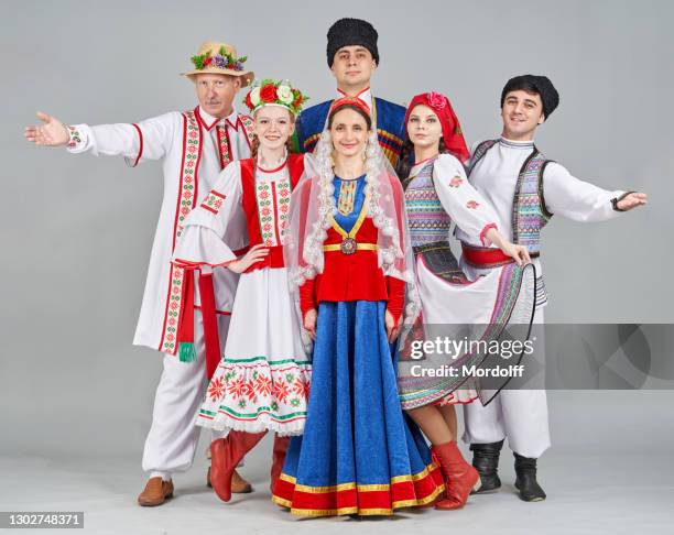 three pairs of dancers in belarus, georgia and moldova folk clothes are standing and looking cheerfully at camera - traditional clothing stock pictures, royalty-free photos & images