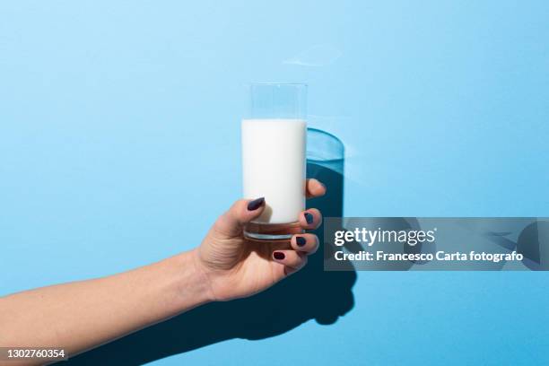 woman holding glass of milk - drink milk foto e immagini stock