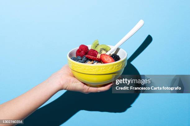 woman's hand holding bowl with muesli - avena cereali da colazione foto e immagini stock