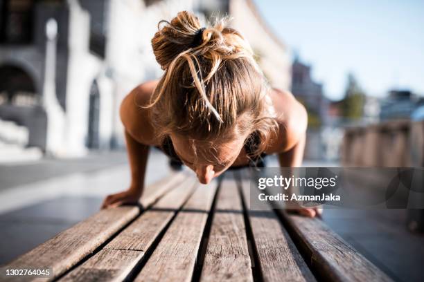 athletische kaukasierin frau in ihren 20er jahren tun push-ups - hiit stock-fotos und bilder