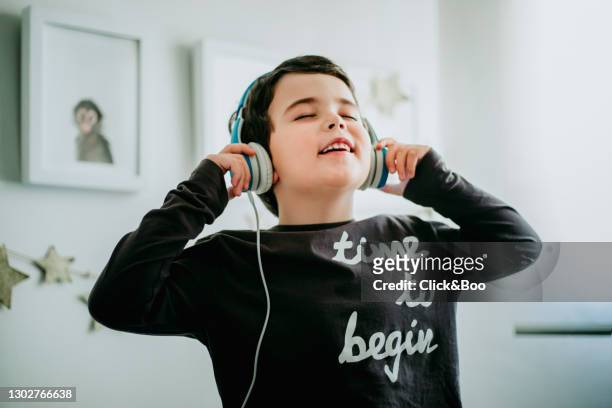 cute happy little boy listening music with headphones indoors - boy headphones imagens e fotografias de stock