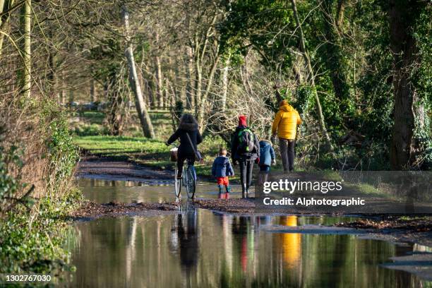 winter walk alongside the river great ouse at st ives - two kids with cycle imagens e fotografias de stock