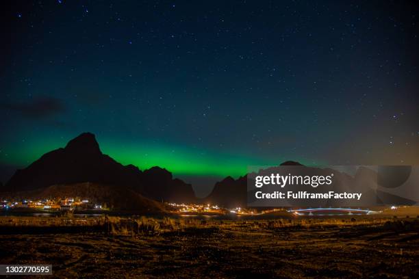 An insane Aurora Borealis or Northern Lights display over the fishing village of Reine, Lofoten Islands, Arctic Norway