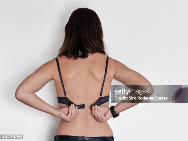 woman removig black bra - sostén fotografías e imágenes de stock