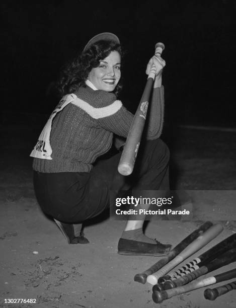 American actress and singer Jane Russell holds a baseball bat as she take part in the Runyon Cancer Fund baseball game at Gilmore Stadium, Los...