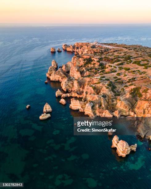cliffs with rock formations at ponta da piedade at sunrise - ponta da piedade imagens e fotografias de stock