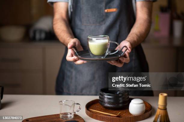 man offering fresh matcha latte green tea beverage - powder tea stock pictures, royalty-free photos & images