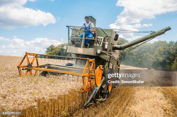 farmer operating combine harvester - agricultural equipment stock pictures, royalty-free photos & images