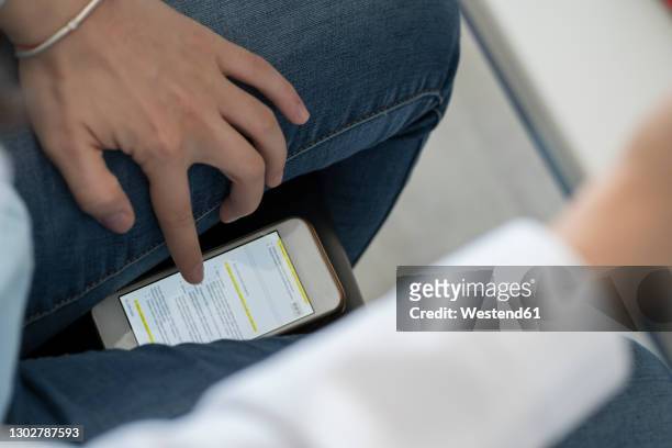 crop view of student scrolling smartphone trying to copy an exam - arnaque photos et images de collection