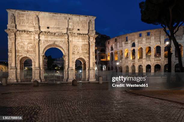 italy, rome, arch of constantine and colosseum at night - arch of constantine stock pictures, royalty-free photos & images