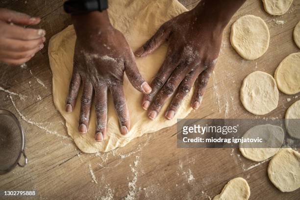 woman kneading dough on wooden table - kneading stock pictures, royalty-free photos & images