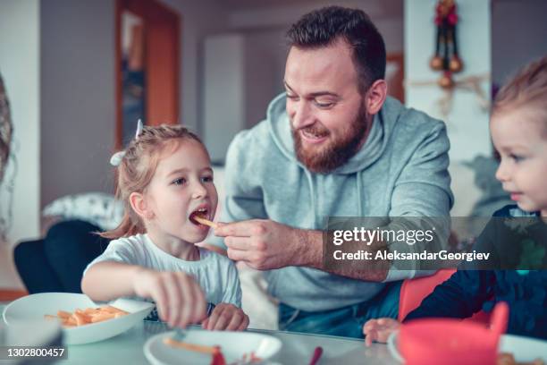 father feeding child daughters with french fries - family eating potato chips stock pictures, royalty-free photos & images