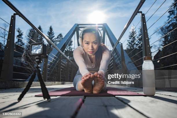 yoga exercises at the bridge and filming whit gopro. - woman smiling facing down stock pictures, royalty-free photos & images