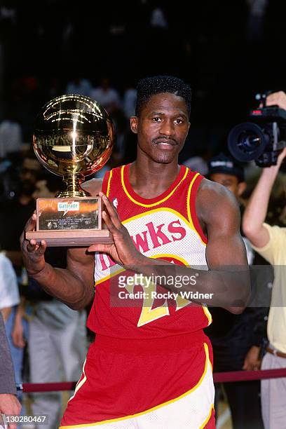 Dominique Wilkins of the Atlanta Hawks holds the trophy after winning the 1990 Slam Dunk Contest as part of the 1990 NBA All-Star Weekend on February...
