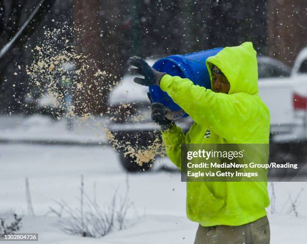 Reading, PA An employee from the Reading Public Works department spreads salt from a bucket on sidewalks in the 400 block of Penn Street. On Penn...