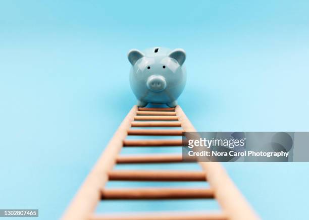 piggy bank climbing a stair - karriereleiter stock-fotos und bilder