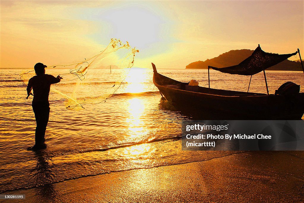 Man throwing net in sea